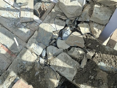 Sensor cables laid into the stone masonry as the wall goes up. Every cable is led out on the inside face, so a stack can be reconnected later.