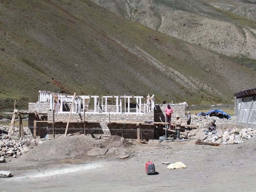 The hall on 24 September 2026: stone walls at window height, timber window frames set in.